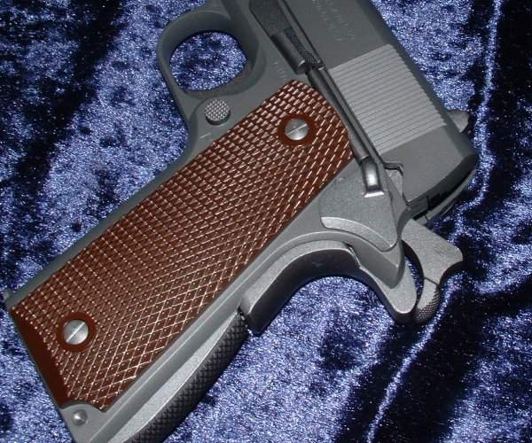 Curved backstrap, longer hammer spur, simpler grips and longer grip safety differ from 1911.