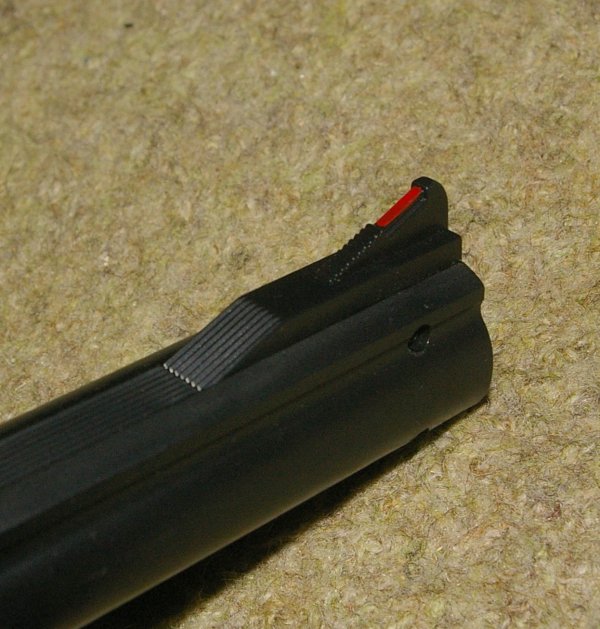 Screws visible on barrel and frame. Note red sight marking.