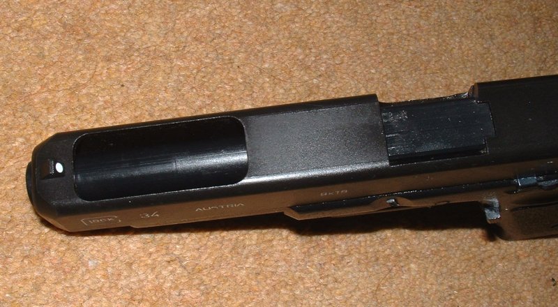 Opening top to front of slide, revealing outer barrel.