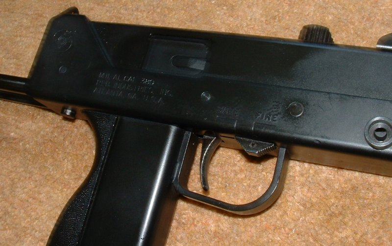 Safety in trigger guard. Note stock release button at rear of receiver.