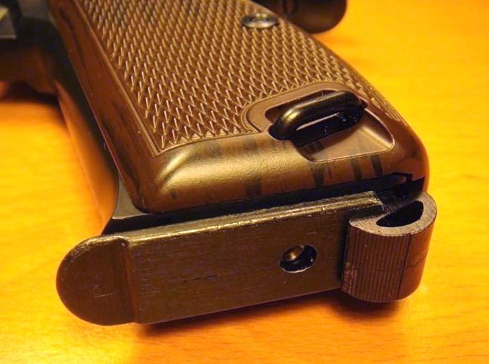 Old fashioned grip base magazine catch - No danger of losing magazine, but slow.
